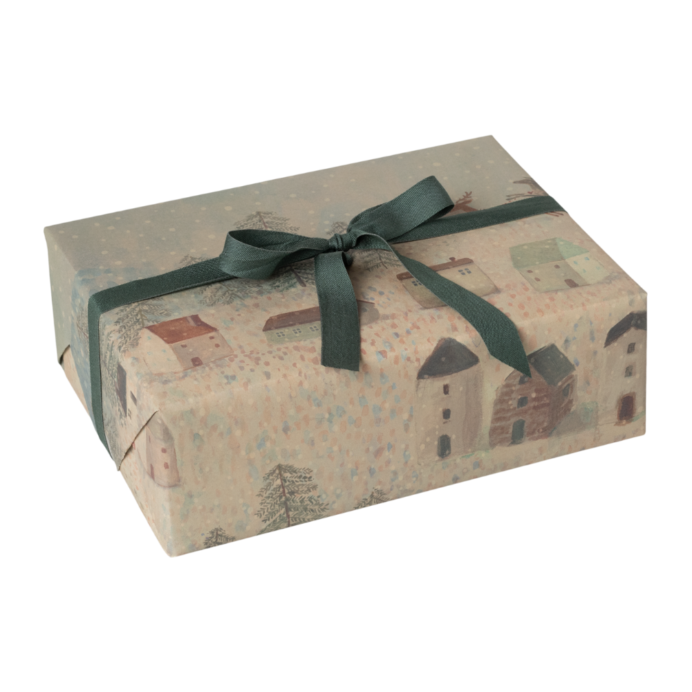 Ein Geschenk eingepackt mit Geschenkpapier von Maileg mit weihnachtlichen Motiven.