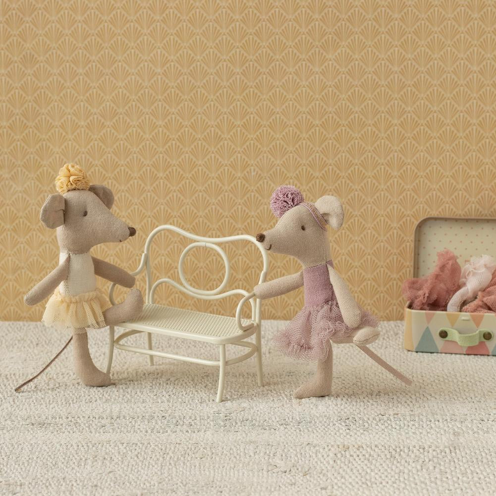 Zwei kleine Ballerinamäuse von Maileg im Tutu machen Dehnübungen an einer Bank.