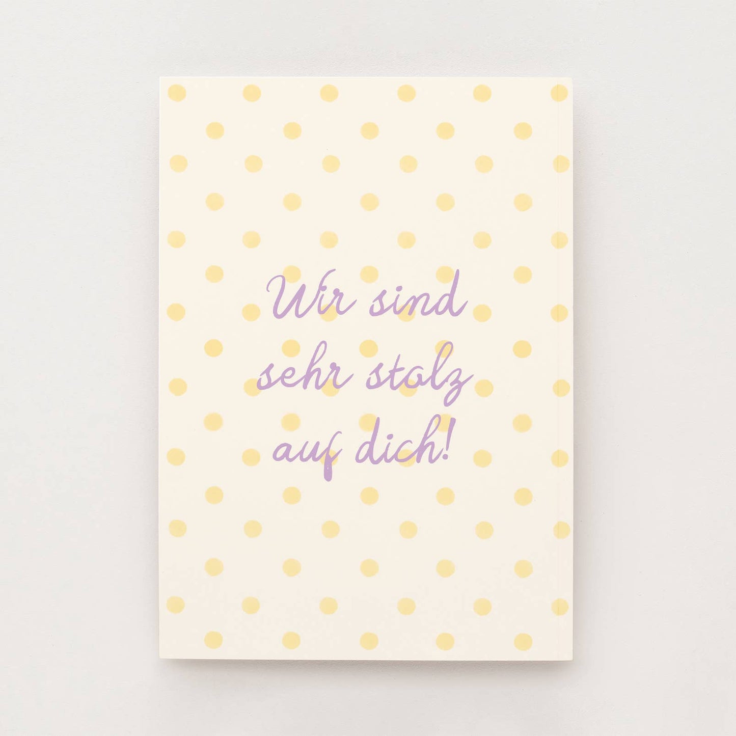 Cremefarbene Postkarte mit gelben Punkten und dem Schriftzug "Wir sind sehr stolz auf dich"