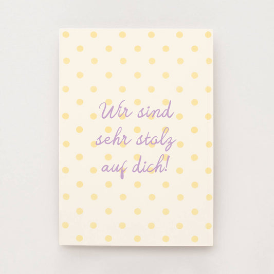 Cremefarbene Postkarte mit gelben Punkten und dem Schriftzug "Wir sind sehr stolz auf dich"